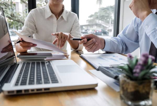 Business professional reviewing loan management software dashboard on a laptop.