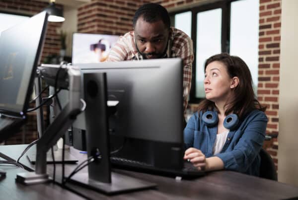 A team collaborating on loan servicing software implementation strategies with laptops and documents on a conference table.