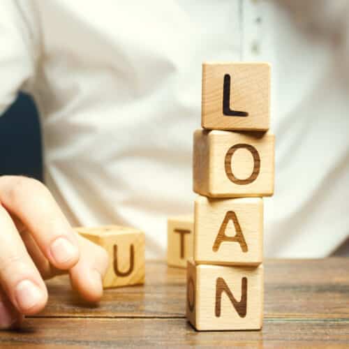 Financial professionals comparing installment loan and line of credit performance data in a modern office setting